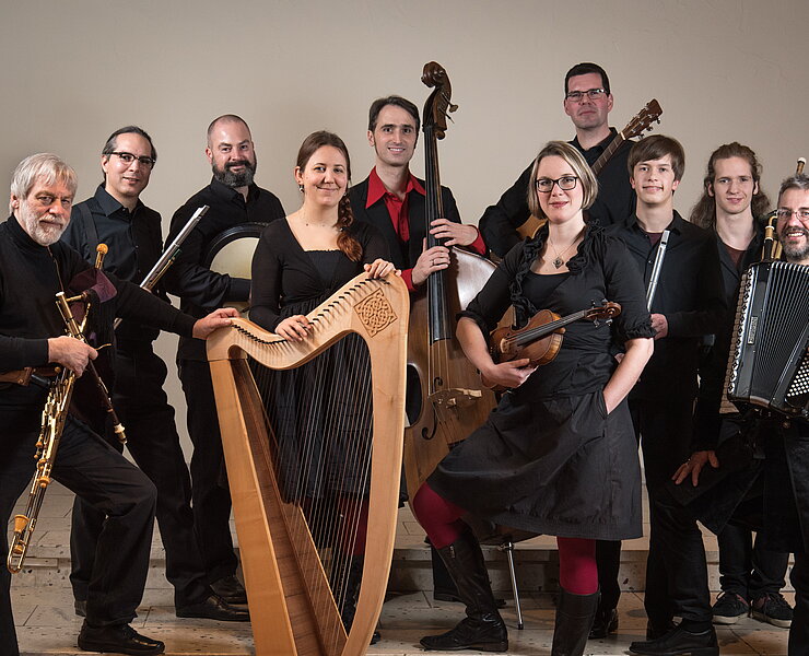 Eine 10 Köpfige Bänd mit diversen Blas-, Seiten-, und Sonstigen- Instrumenten alle in Schwarz gekleidet.