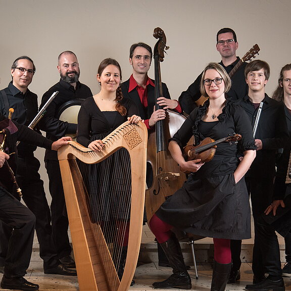 Eine 10 Köpfige Bänd mit diversen Blas-, Seiten-, und Sonstigen- Instrumenten alle in Schwarz gekleidet.