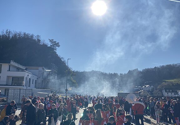 Rosenmontagszug in Altenahr-Altenburg mit Kostümen und Musik vor sonniger Kulisse im Ahrtal.