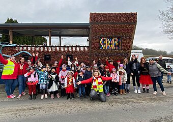 Aufstellung von als Piraten verkleideten Kindern und Erwachsenen von einem Karnevalsumzugswagen der aussieht wie ein Schiff