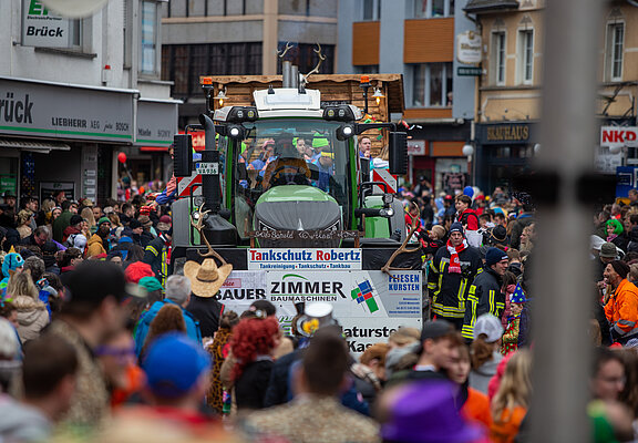 Karnevalszug in Adenau mit festlich geschmücktem Traktor und bunt kostümierten Besuchern, Verbandsgemeinde Sonntags Zug.