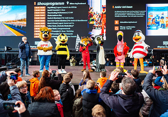 Verschiedene Tier-Maskottchen stehen auf einer Bühne