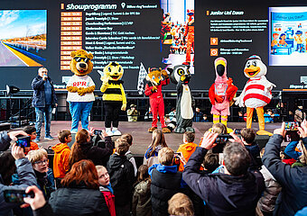 Verschiedene Tier-Maskottchen stehen auf einer Bühne