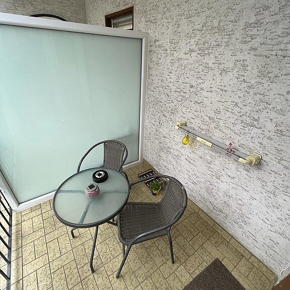 Balkon mit Wäscheleine und Sitzgelegenheit