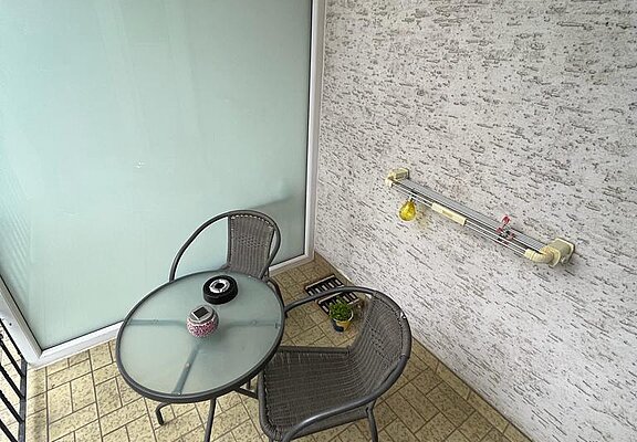 Balkon mit Wäscheleine und Sitzgelegenheit